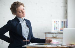 Young businesswoman with back pain