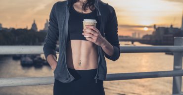 Athletic young woman with cup in London at sunrise