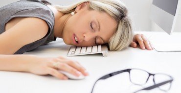Exhausted woman sleeping in front of computer
