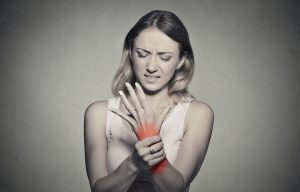 woman holding her painful wrist