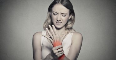 woman holding her painful wrist