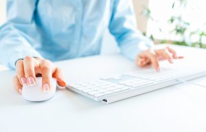 Woman office worker typing on the keyboard