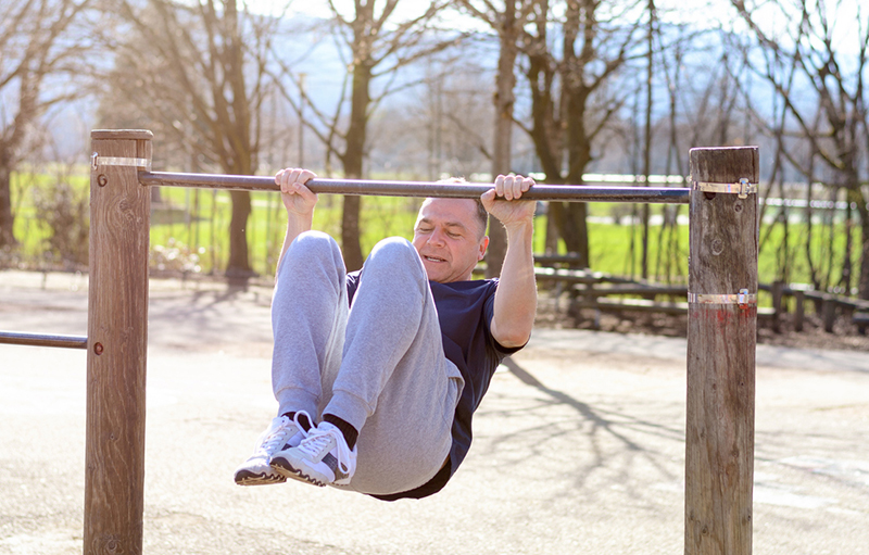 Middle-aged man working out on a horizontal bar