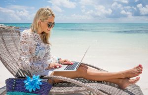 Businesswoman with computer on the beach