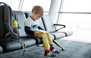 Little boy playing on his tablet in airport