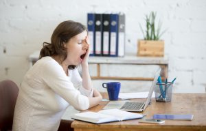Sleepy young worker woman yawning