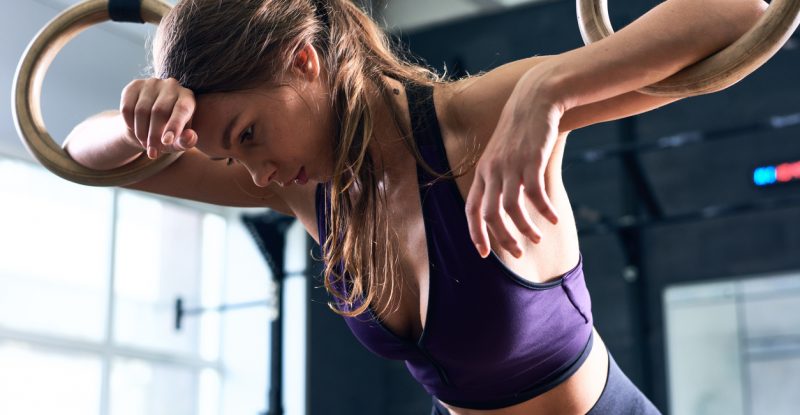 Exhausted Woman Training on Gymnastic Rings