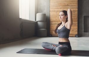 Young woman in yoga class, back stretching