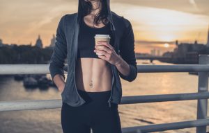 Athletic young woman with cup in London at sunrise