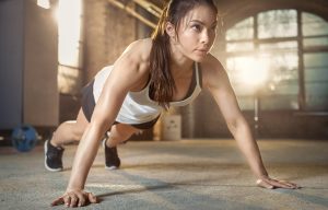 Athletic Beautiful Woman Does Push-ups as Part of Her Cross Fitness, Bodybuilding Gym Training Routine.